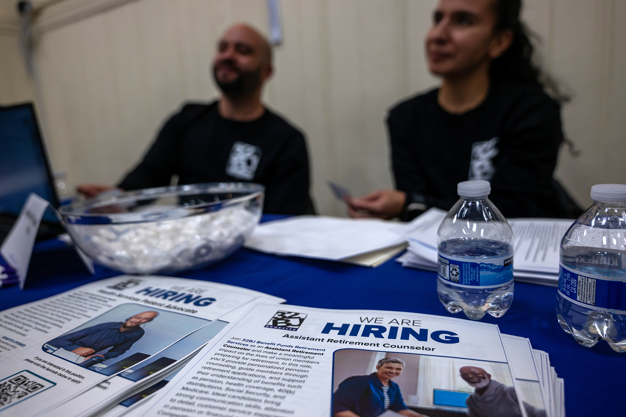 Business representatives staff a table at a career fair in Harlem in December 2025.