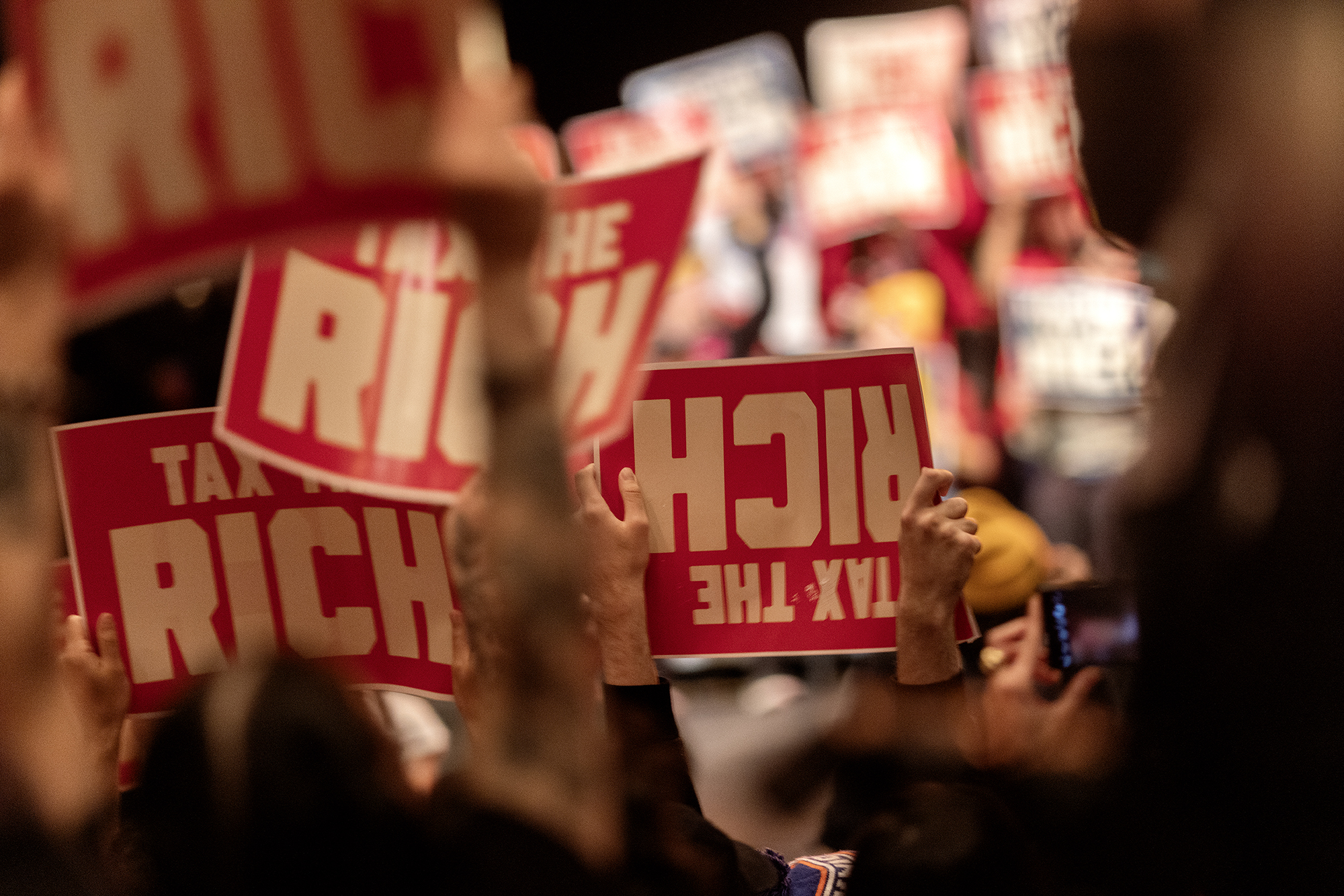 People attend a Tax The Rich political rally hosted by the Democratic Socialists of America.