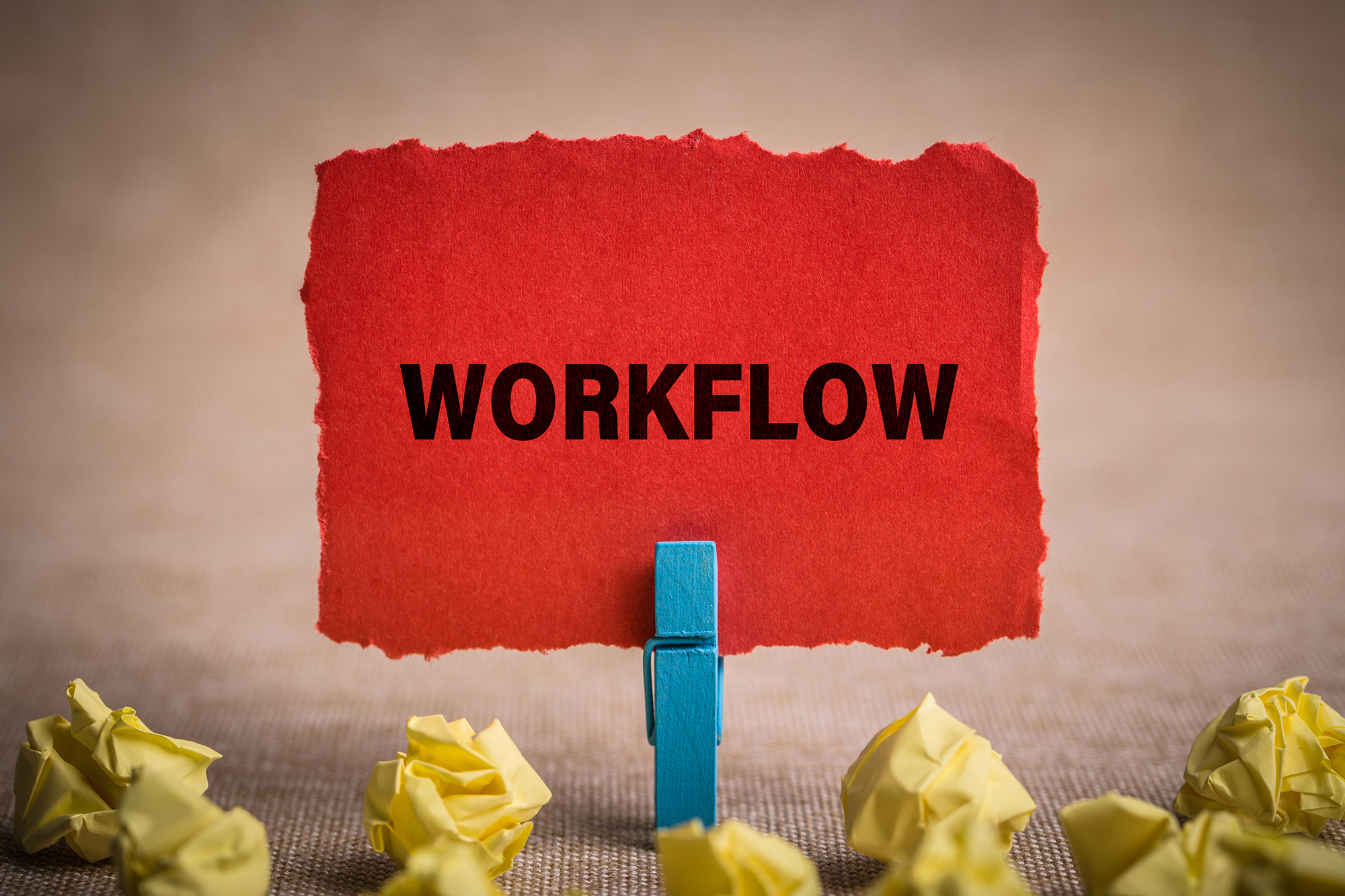 The word "Workflow" printed on a piece of red paper held by a clothespin.
