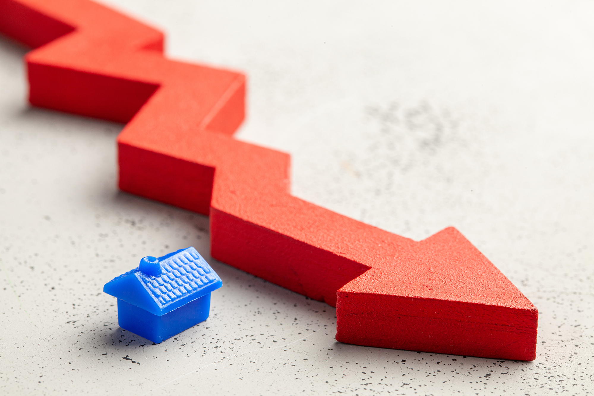 An illustration of a small toy house and red arrow pointing down.