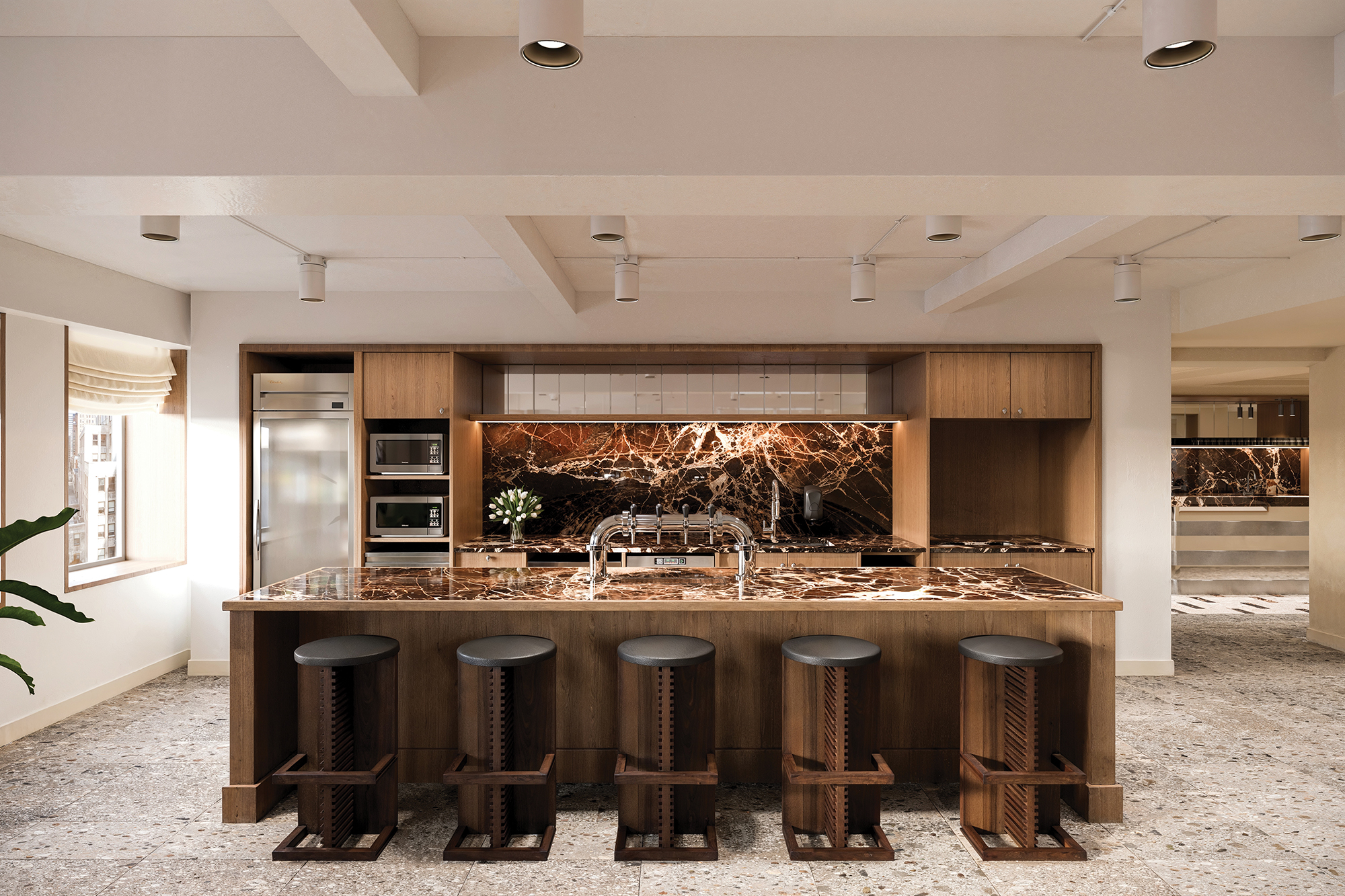 A granite-topped kitchen with stainless steel fixtures and modern bar stools.