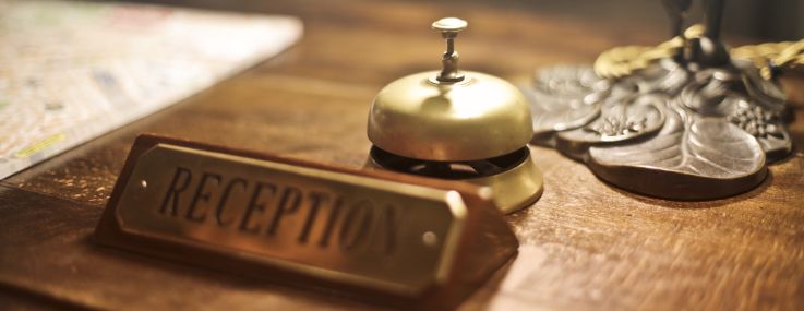 An old-time front desk bell at a reception desk.