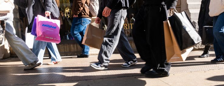 People walk with shopping bags.