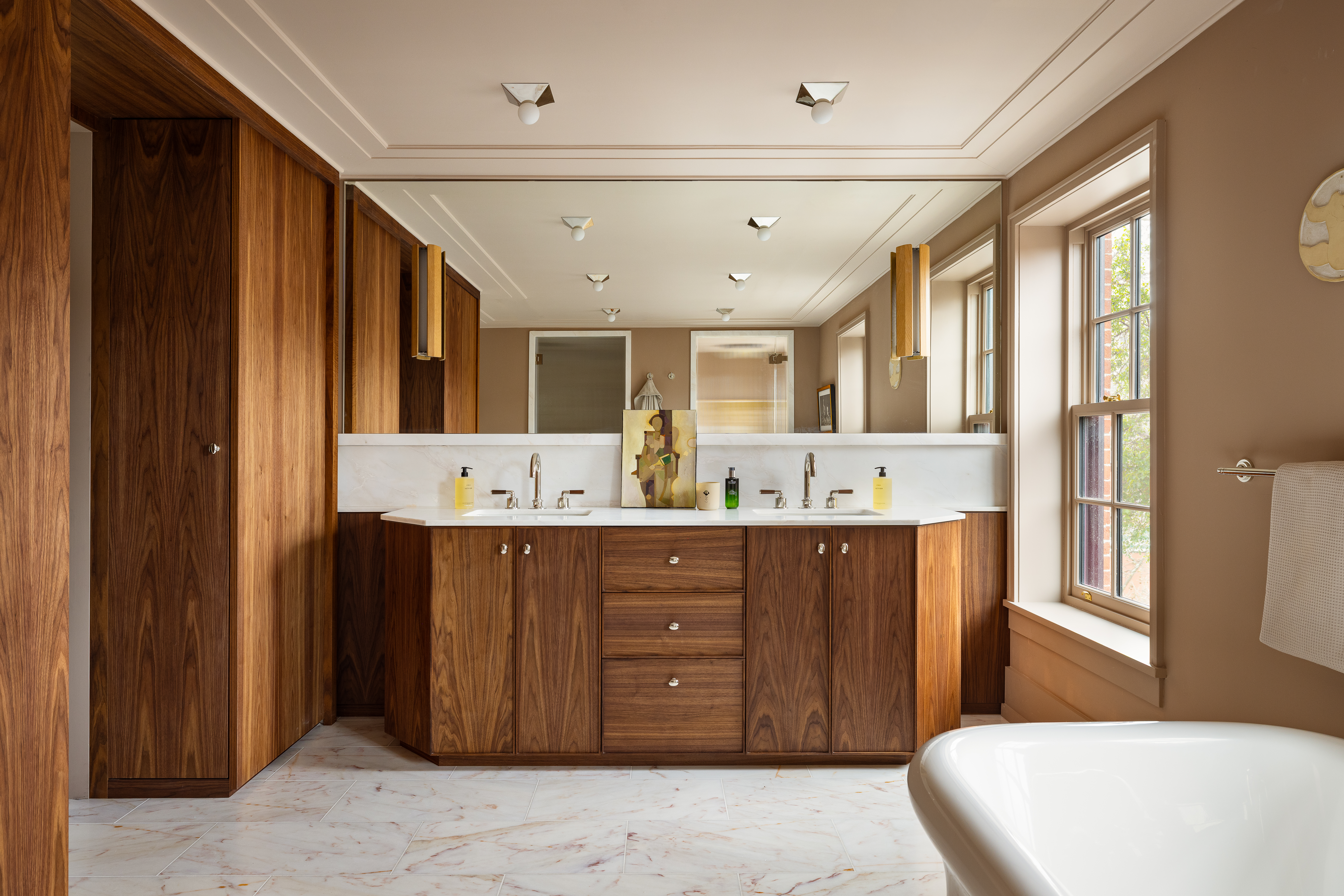 The main bathroom features a free-standing, deep-soaking tub, a separate closed-door stall for the toilet, and a separate stall for the steam shower.