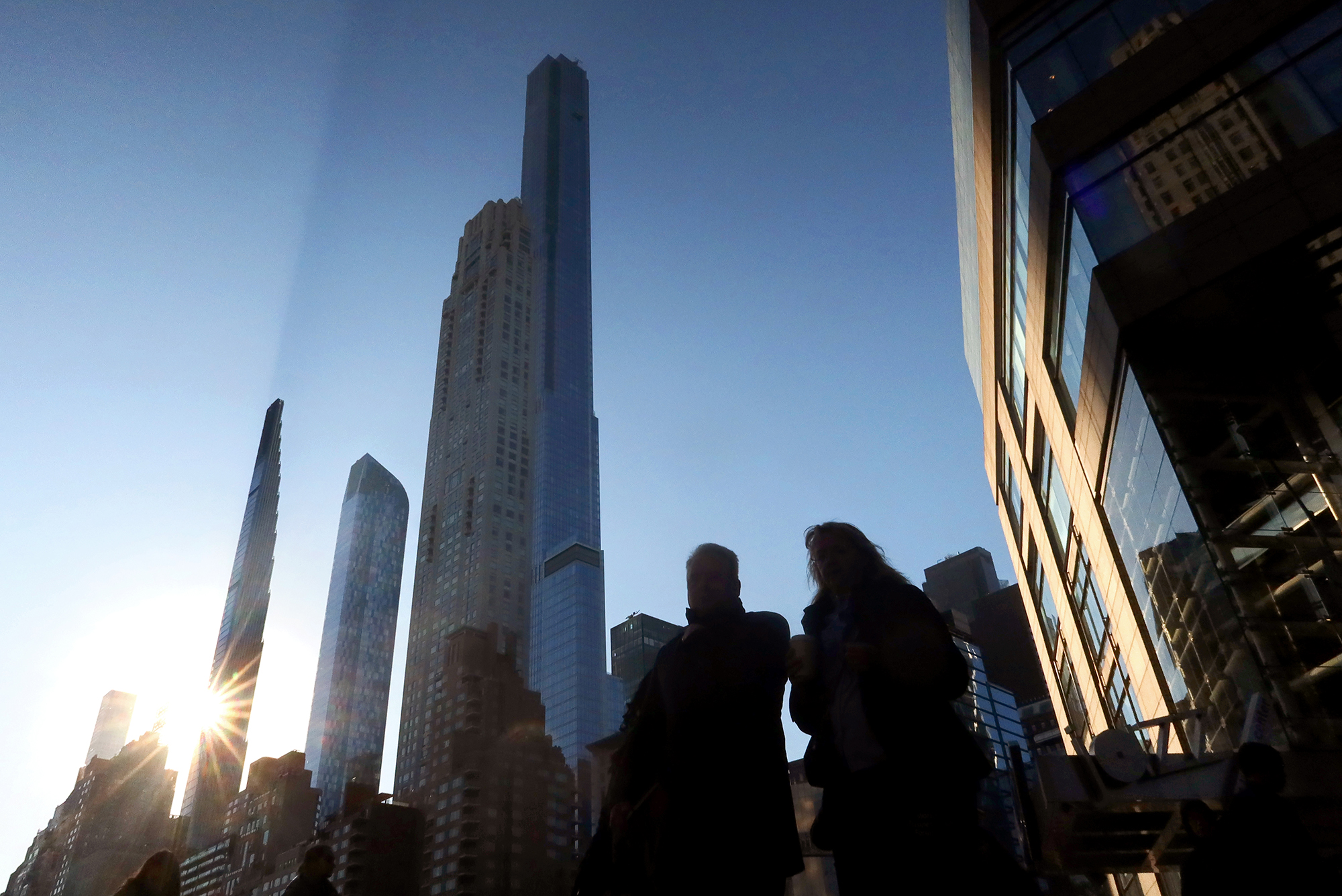 The sun rises behind the Steinway Tower as it casts a shadow along Billionaires' Row in Manhattan.