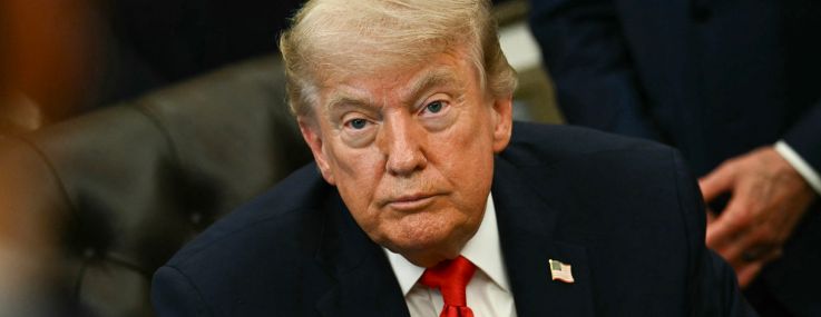 President Donald Trump sits in the Oval Office of the White House before signing a proclamation in June.