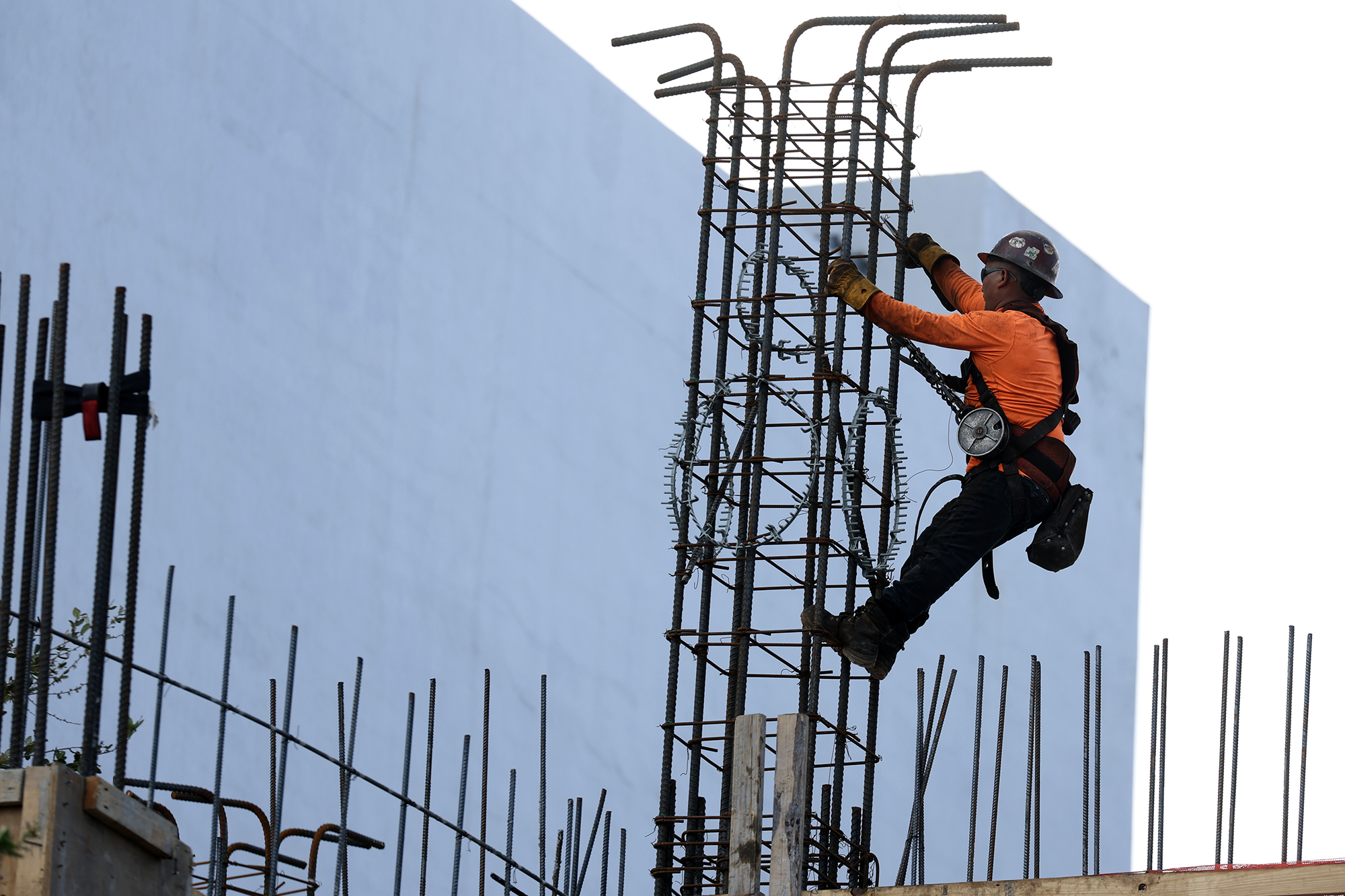 A construction worker helps build a support column using steel rebar in Miami.