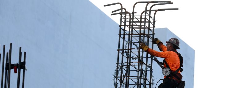 A construction worker helps build a support column using steel rebar in Miami.