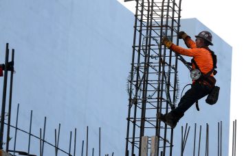 A construction worker helps build a support column using steel rebar in Miami.