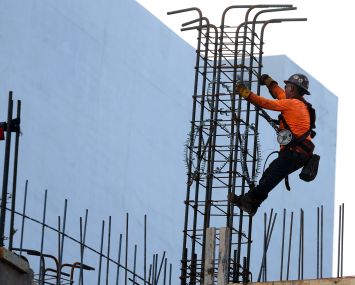 A construction worker helps build a support column using steel rebar in Miami.