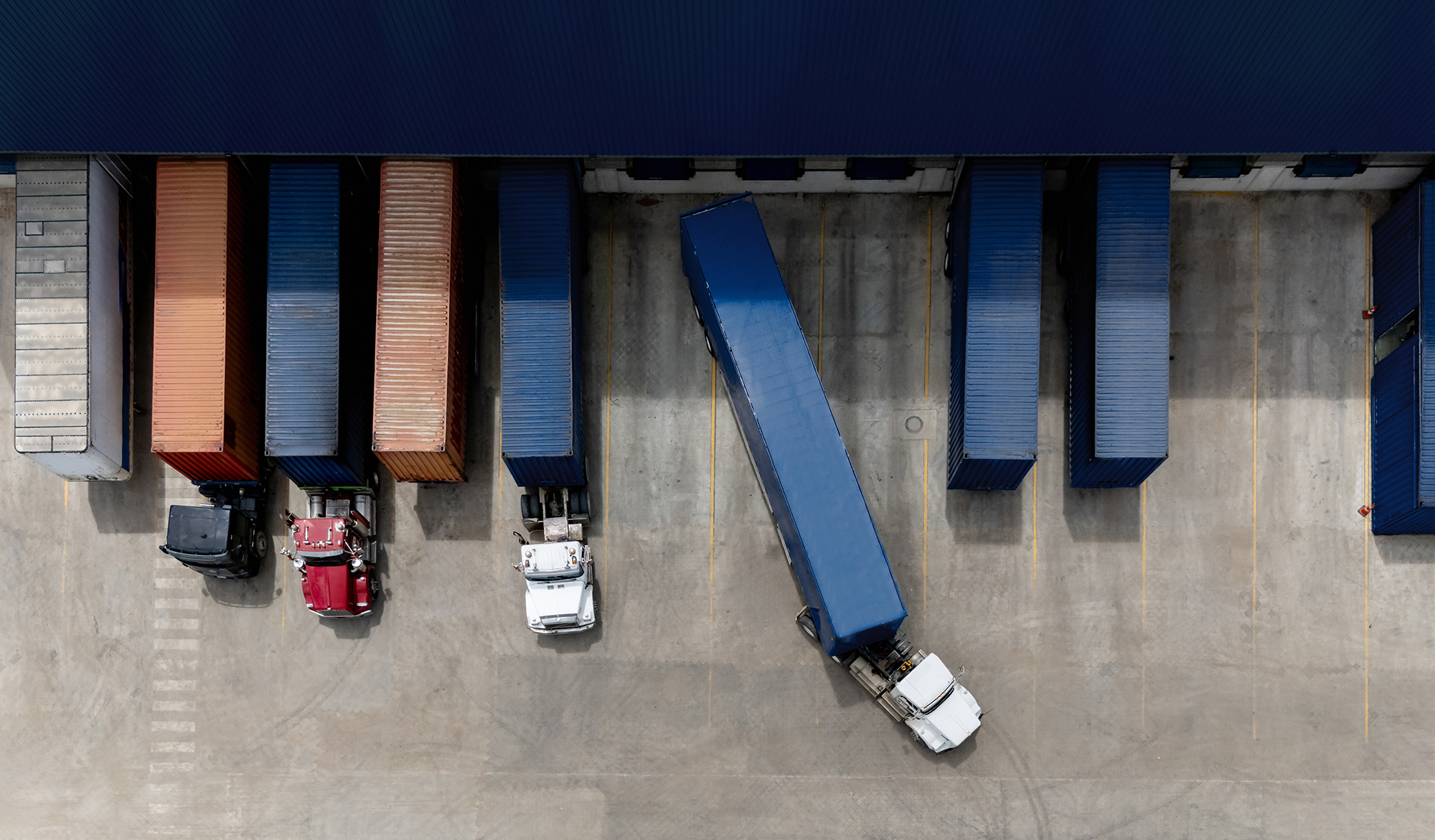Aerial view of a truck leaving the loading dock at a distribution warehouse.