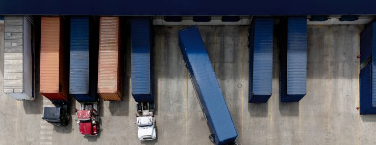 Aerial view of a truck leaving the loading dock at a distribution warehouse.