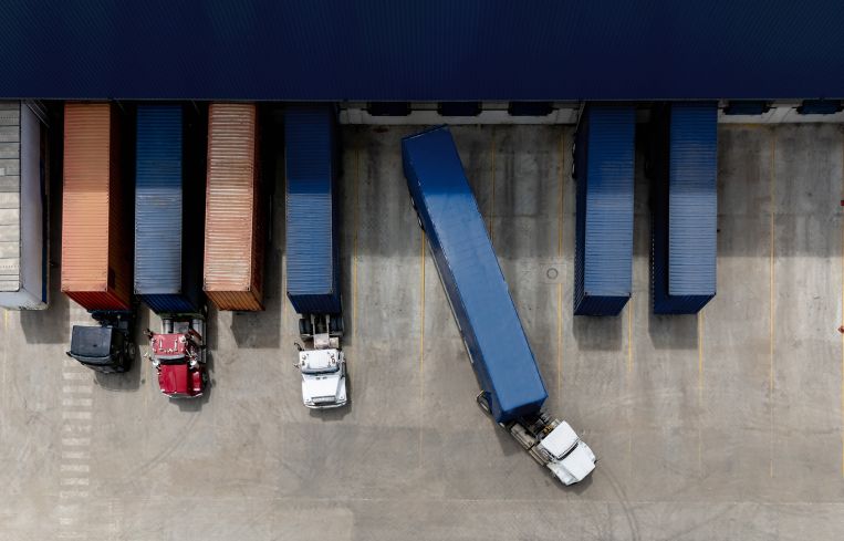 Aerial view of a truck leaving the loading dock at a distribution warehouse.