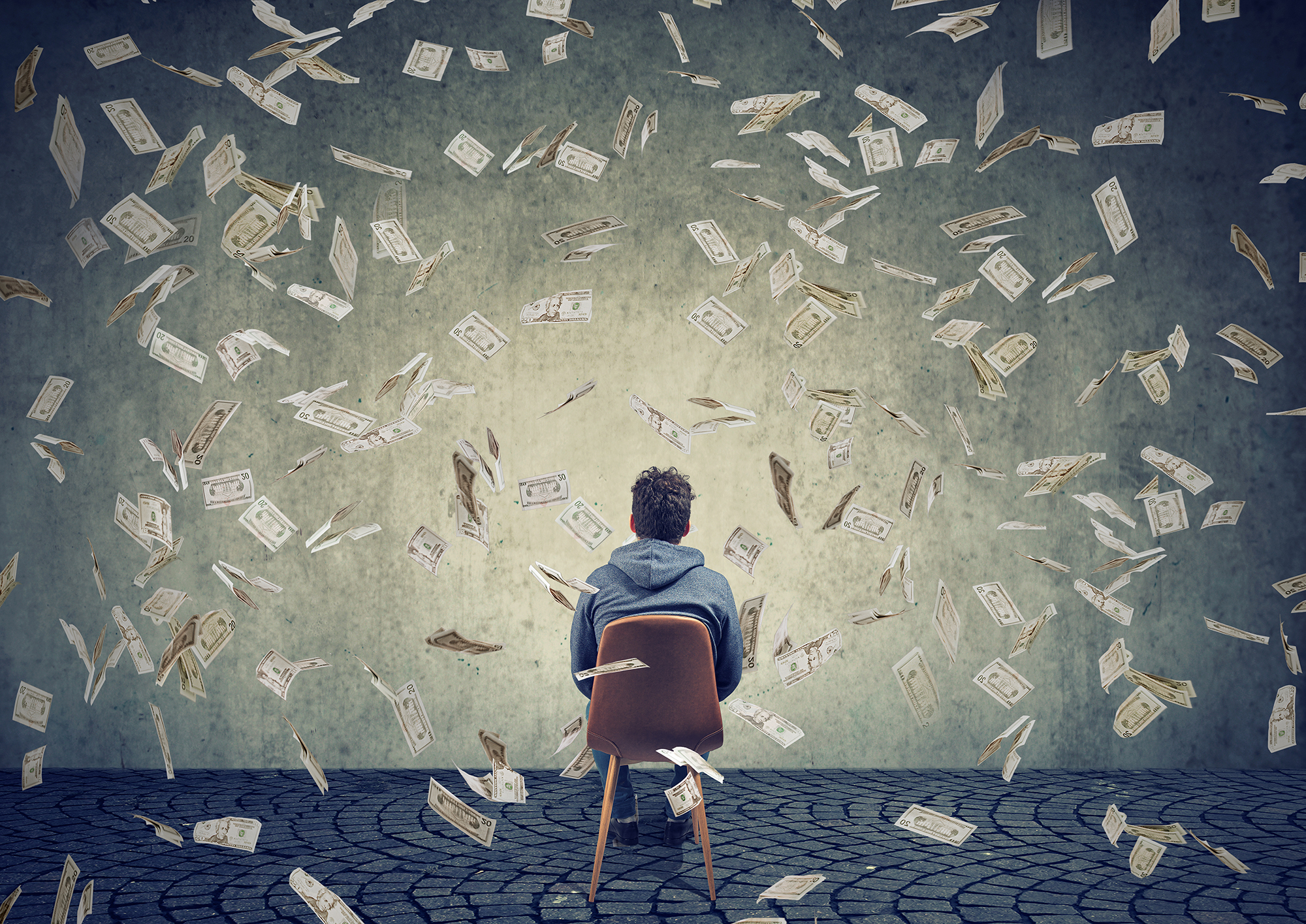 An illustration of a man sitting in a chair with money falling all around him.
