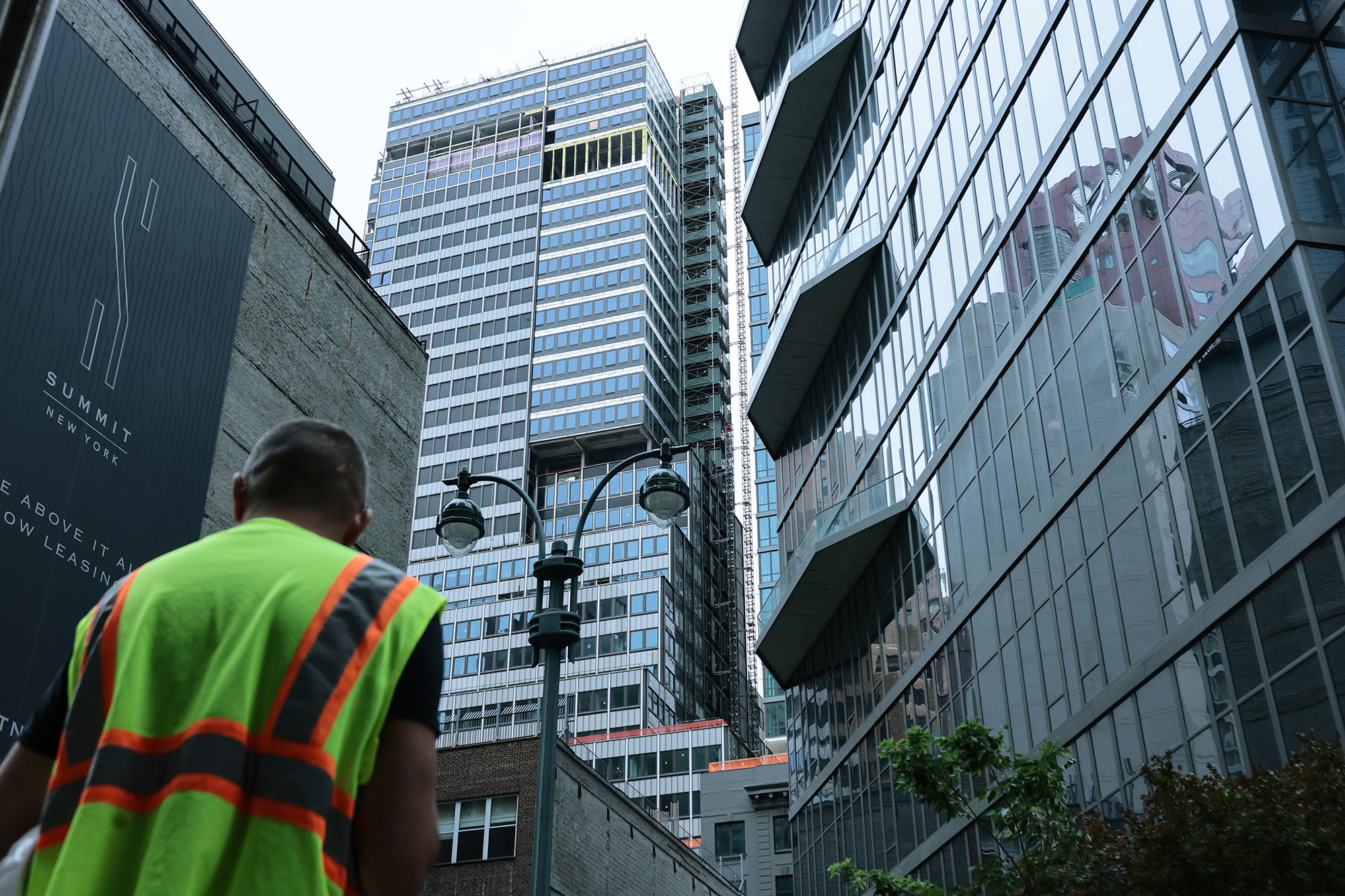 A construction worker stands near the former Pfizer headquarters building at 235 East 42nd Street after the building was evacuated when it was determined that it was at risk of collapse.