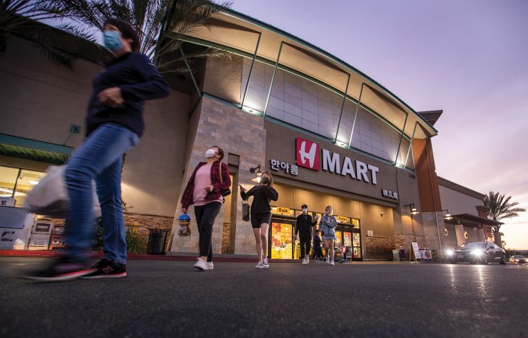Shoppers exit the H Mart at Diamond Jamboree Shopping Center in Irvine, Calif.