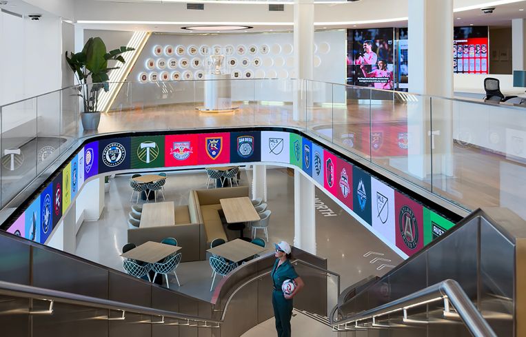 There is a a ticker circling the staircase that leads down into the massive communal space called “Midfield.”