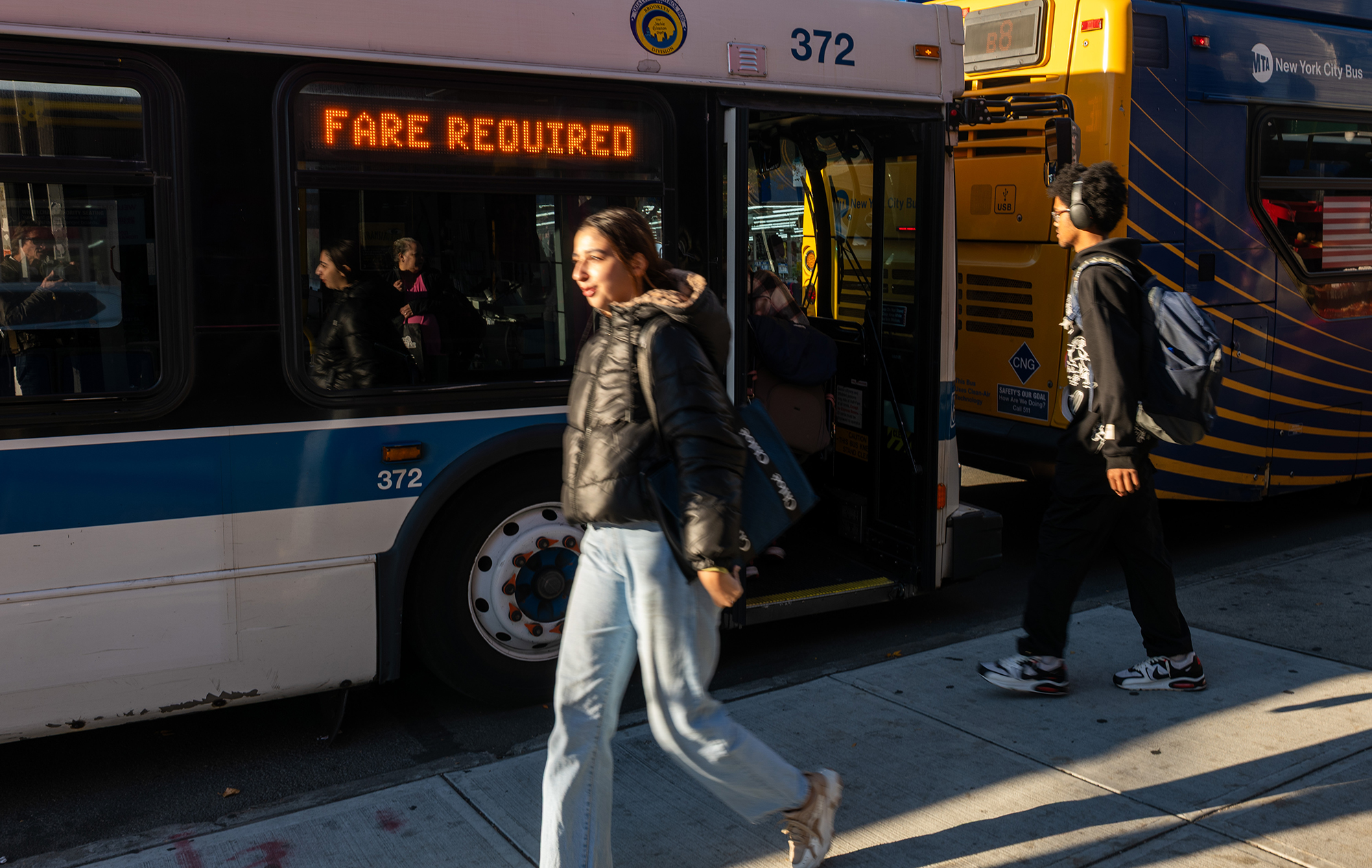 A person boards a city bus in Brooklyn.
