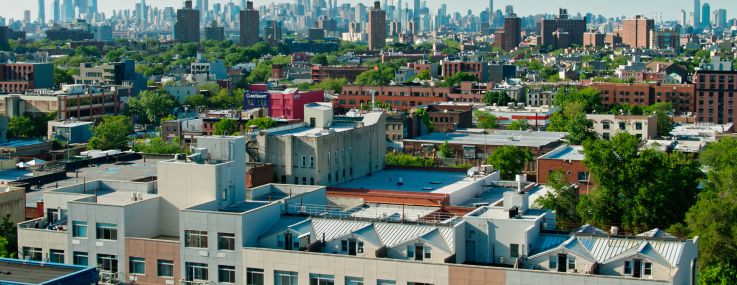 Aerial shot of New York City on a sunny afternoon in summer from over the Crown Heights neighborhood in Brooklyn and looking towards the Manhattan skyline.
