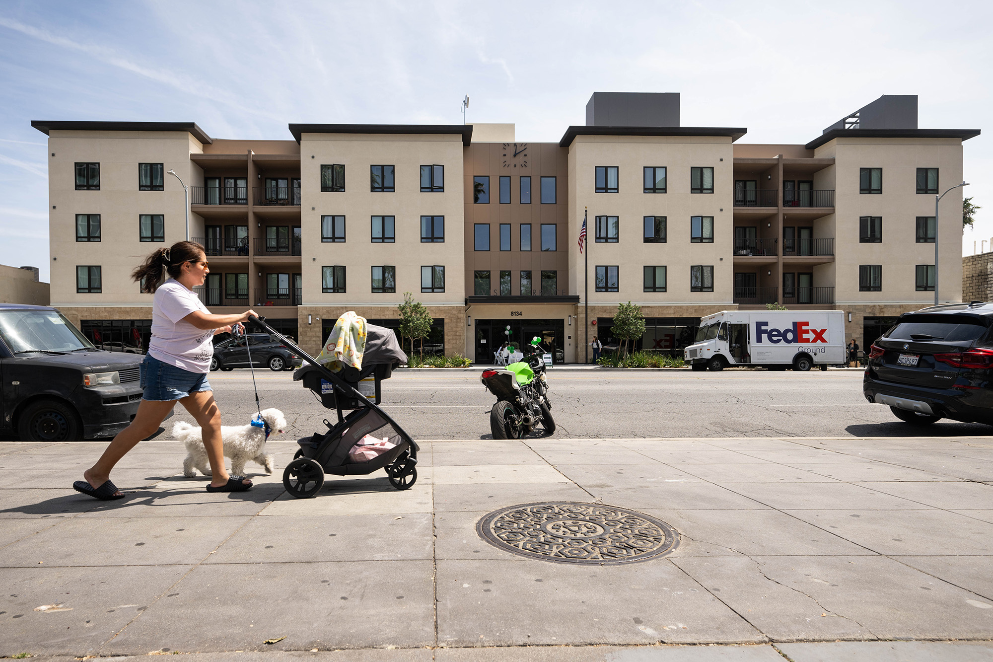 A woman passes by Vista Terrace, a 102-unit, affordable and supportive housing apartment complex on Van Nuys Boulevard in Los Angeles.