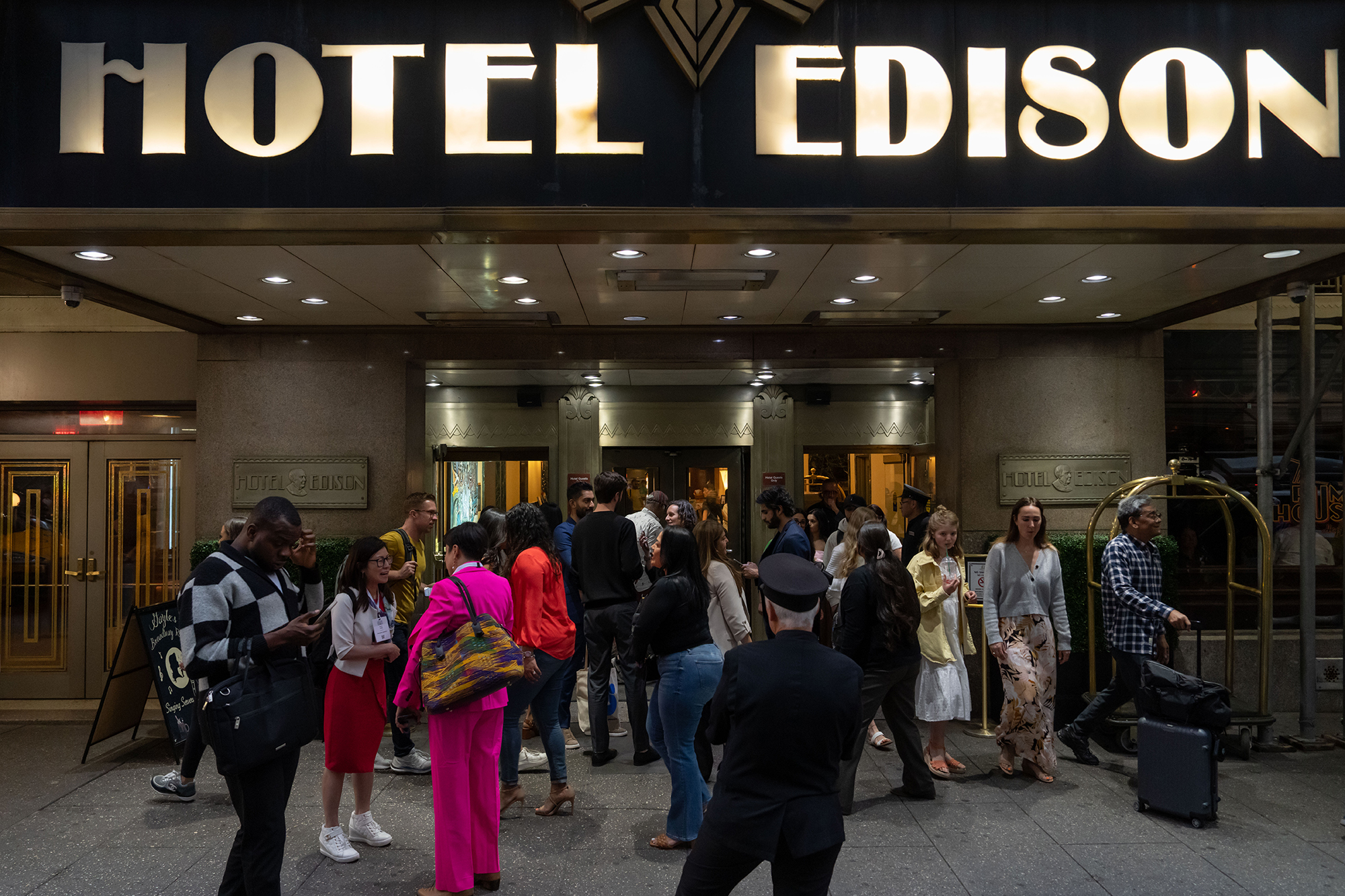 People walk out of Hotel Edison in New York City.
