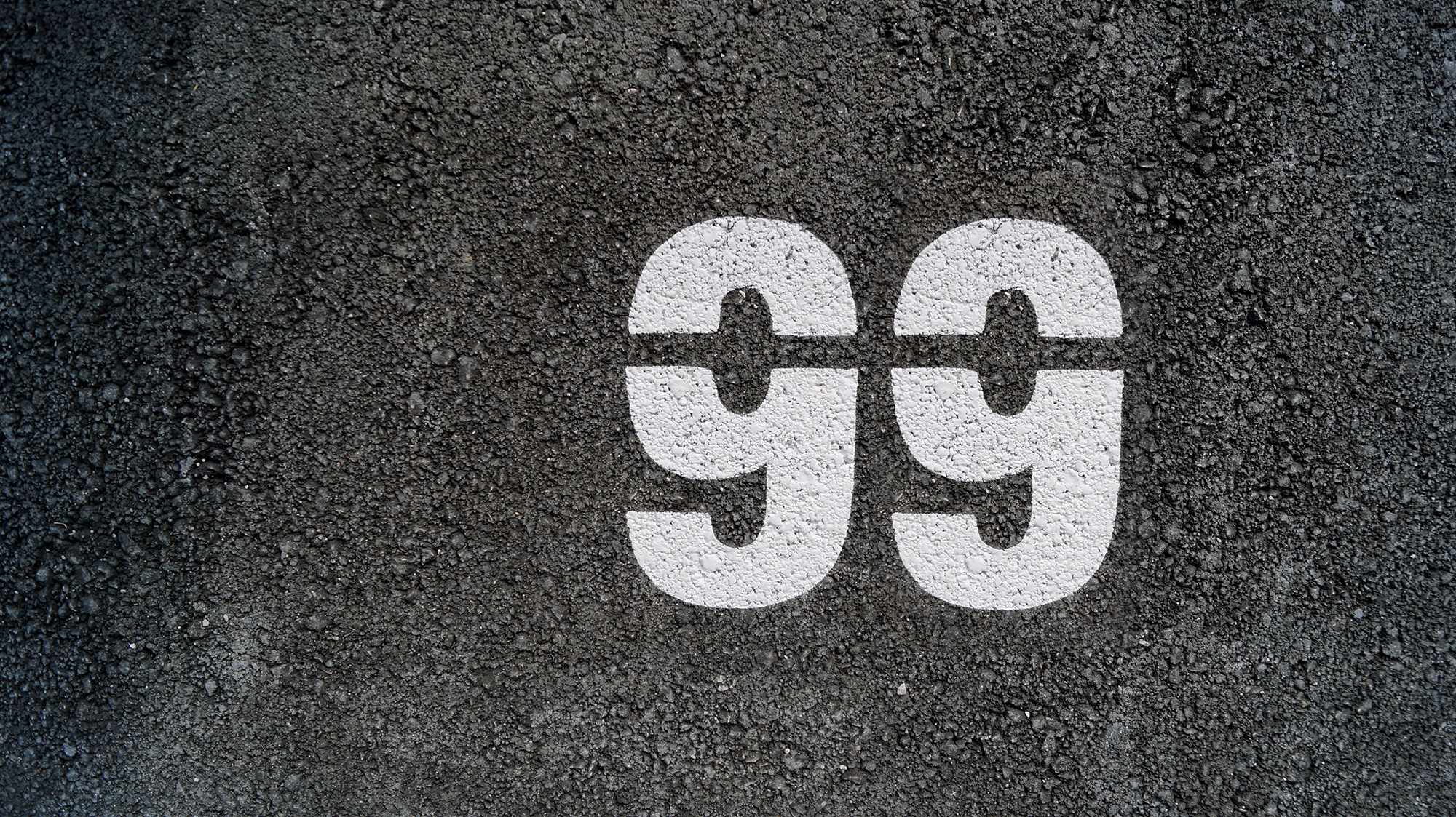 The number 99 painted on asphalt.