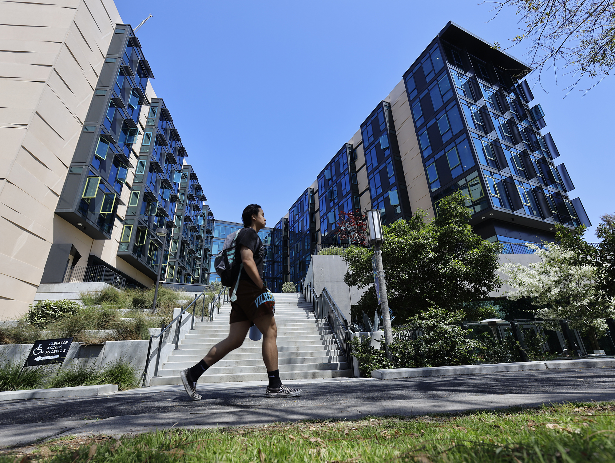 A student walks by the student housing at the University of California-Irvine in Irvine, Calif.