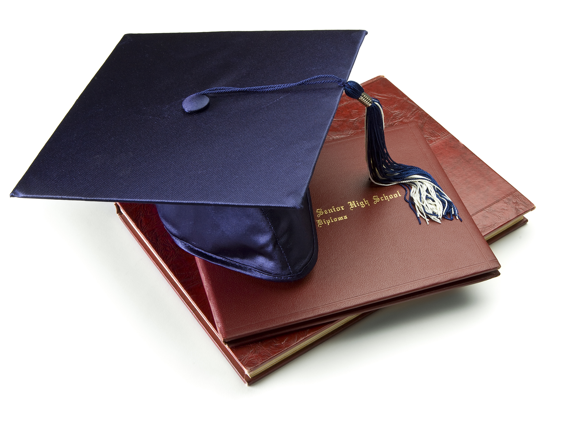 Mortar board on diploma and year book.