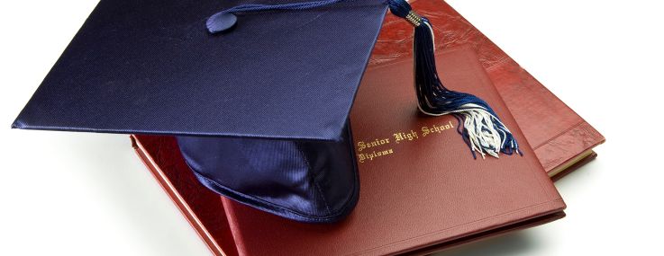 Mortar board on diploma and year book.