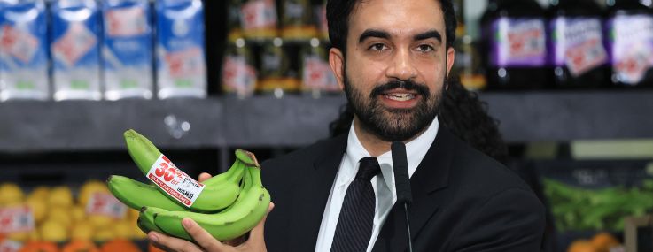 Mayor Zohran Mamdani holds up bananas as he announces five upcoming city-owned grocery stores will offer a 30 percent discount on produce, meat, bread and milk when they open.