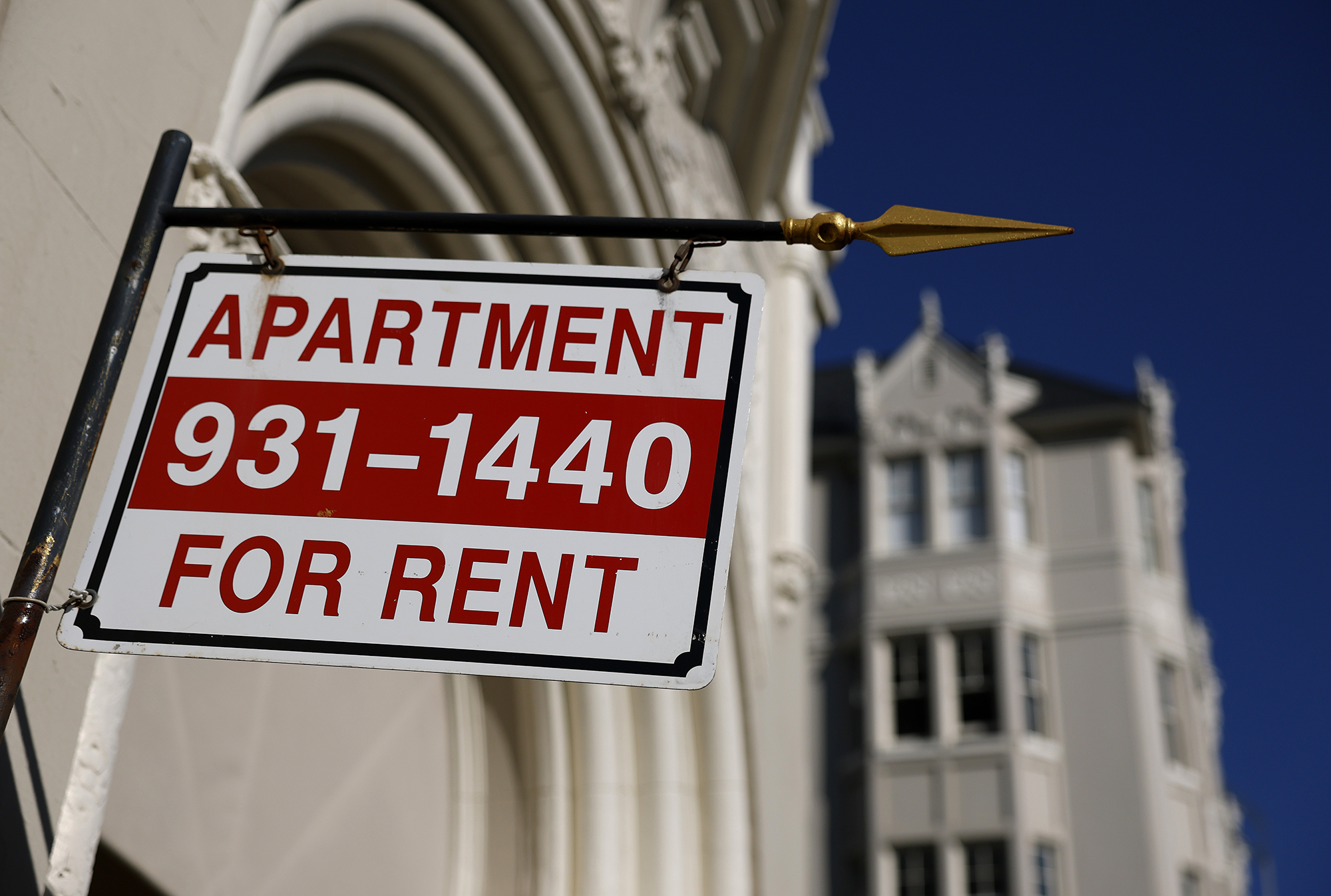 An apartment for rent sign hangs outside of an apartment building in San Francisco.