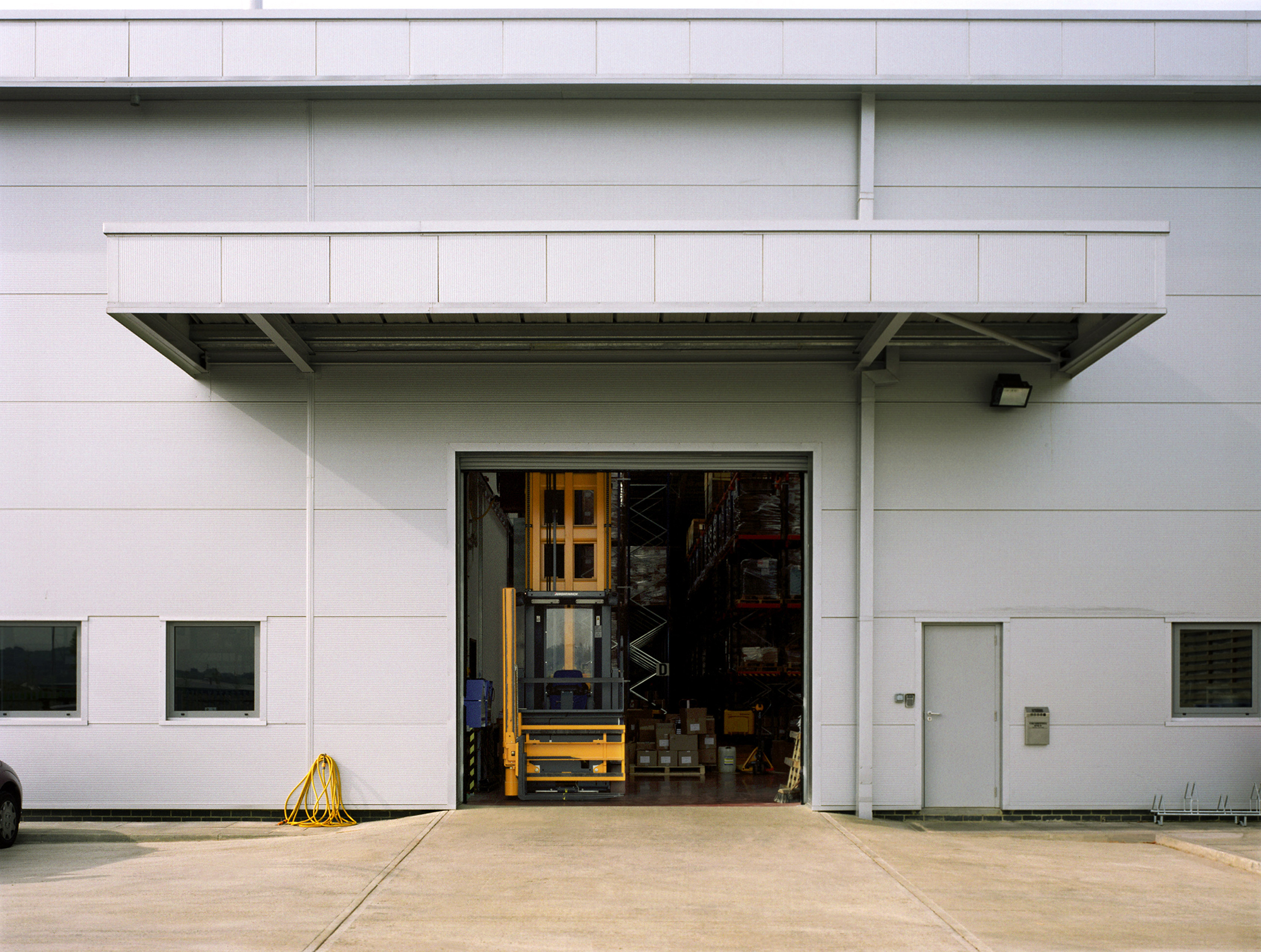 A forklift at the entrance to a warehouse.