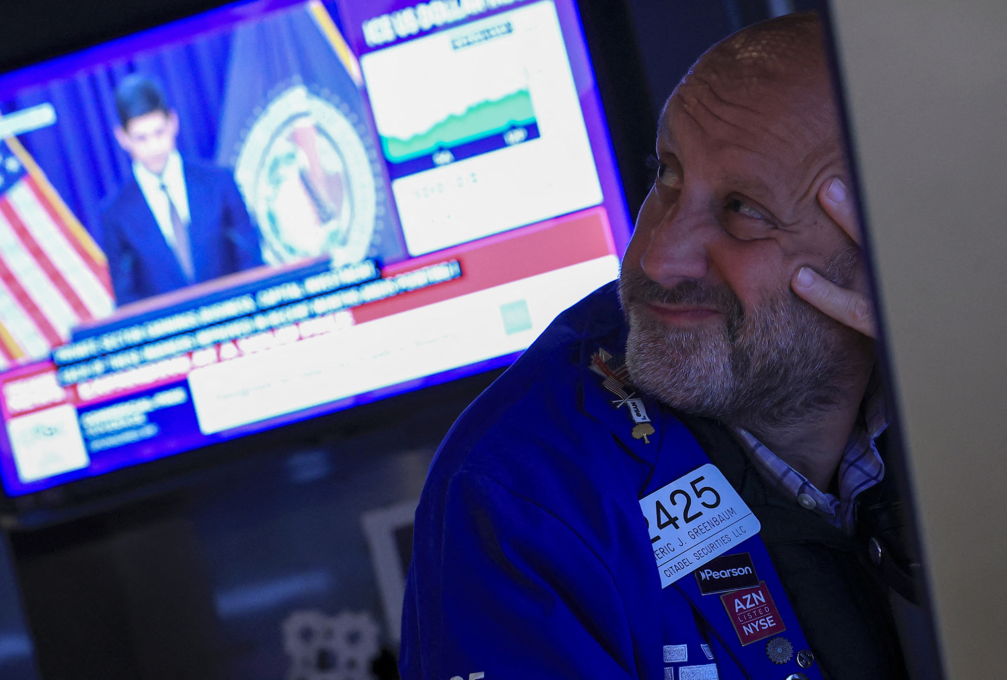 A trader looks on as Federal Reserve Chair Kevin Warsh is displayed on a television screen on the floor of the New York Stock Exchange.
