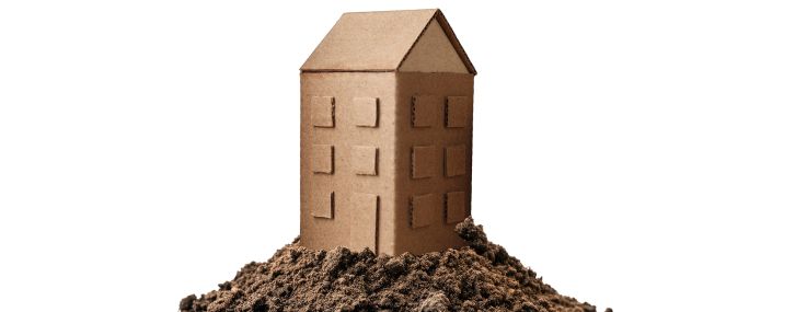 An illustration of a cardboard building on a pile of dirt.