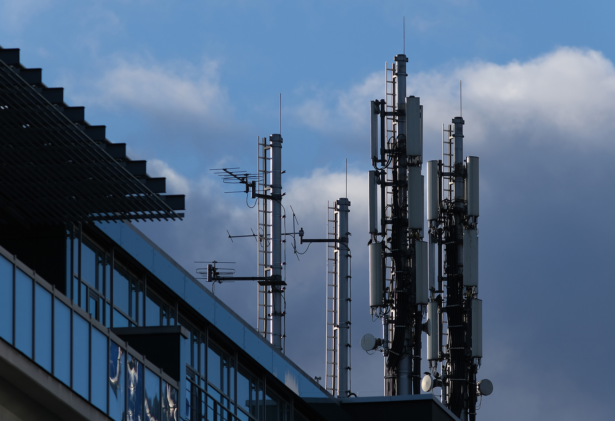A cellular phone tower stands on top of an office building.