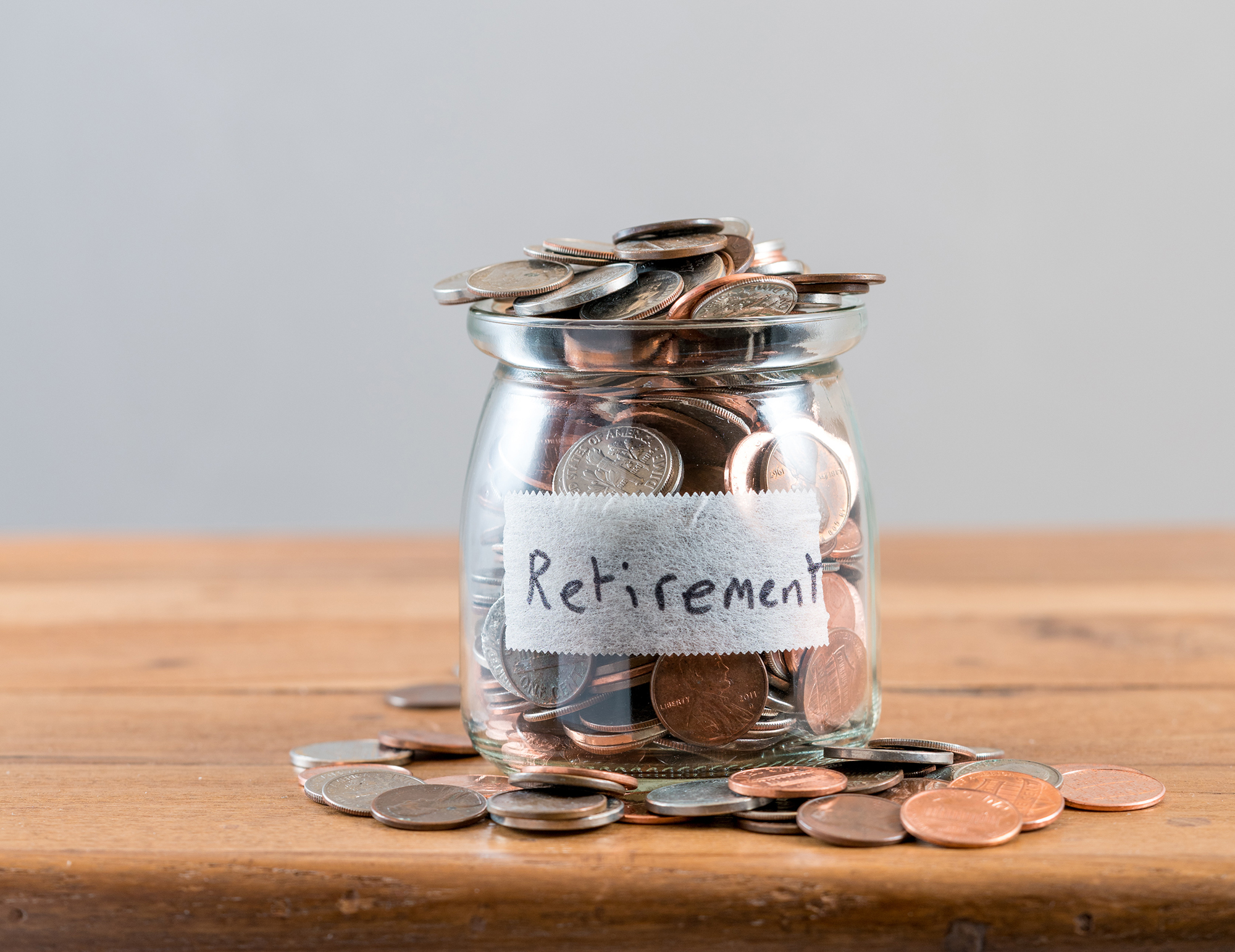 A jar filled with coins labeled "retirement."