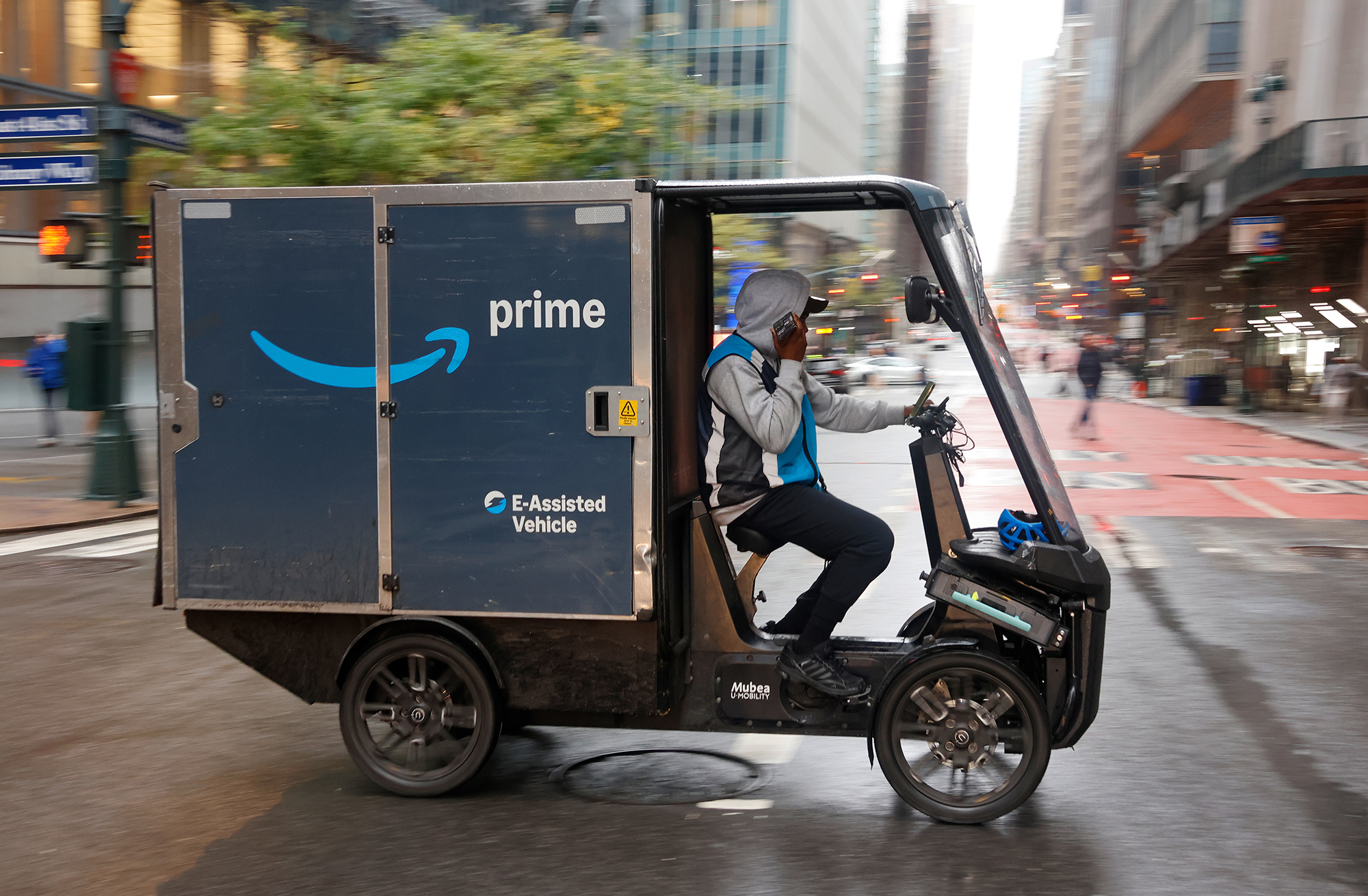 An Amazon delivery person drives an E-Assisted delivery vehicle in Manhattan.