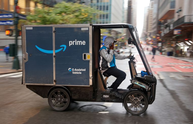 An Amazon delivery person drives an E-Assisted delivery vehicle in Manhattan.