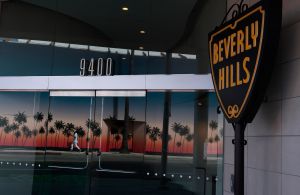 A lone pedestrian is seen reflected in the window of the Beverly Hills Chamber of Commerce.