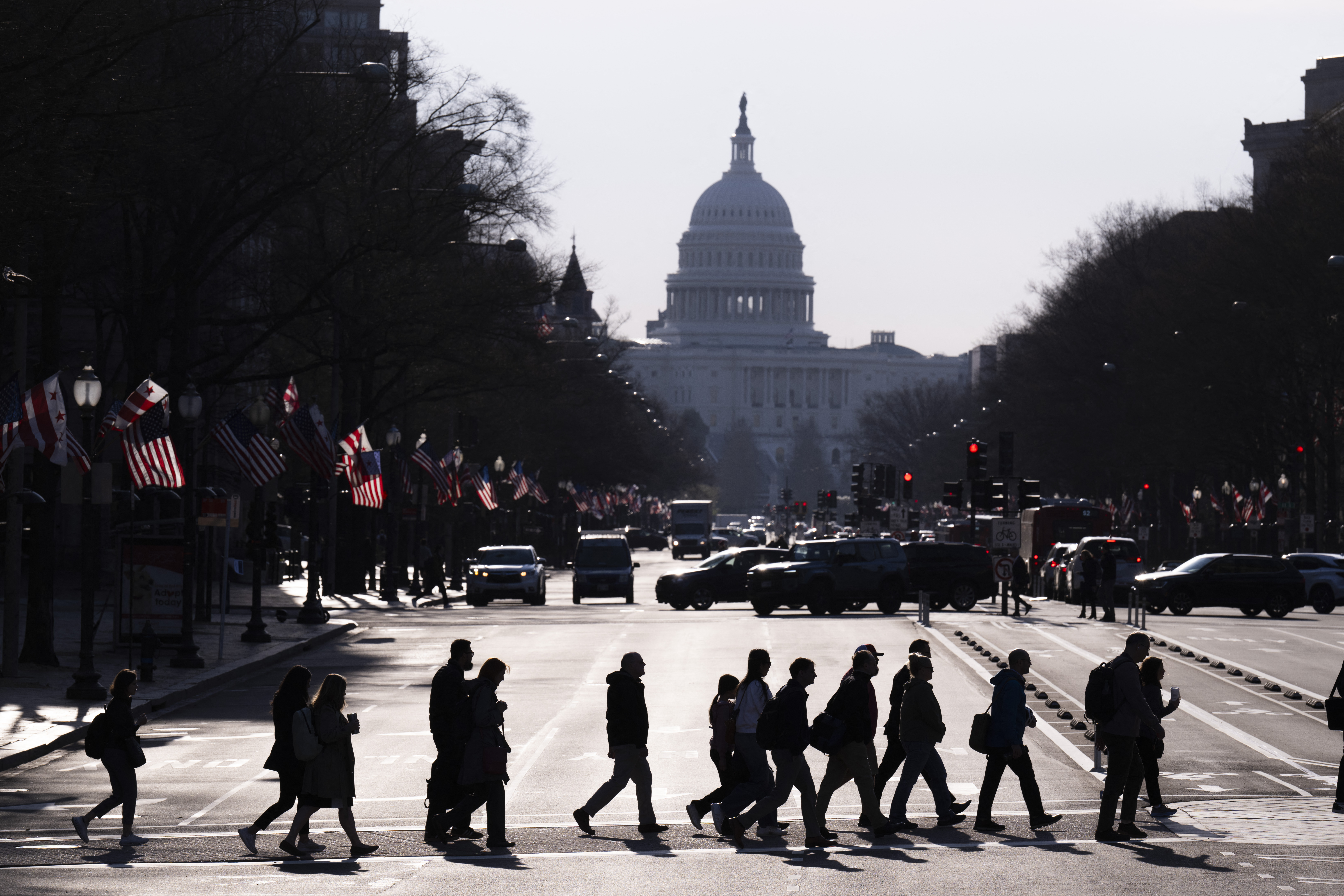 Commuters cross Pennsylvania Avenue in downtown Washington, DC.