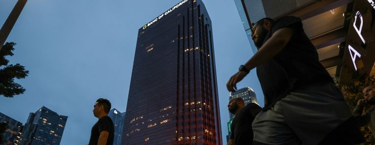 Pedestrians pass by buildings in downtown in Los Angeles.